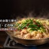 湯気の立つもつ鍋を囲む食卓